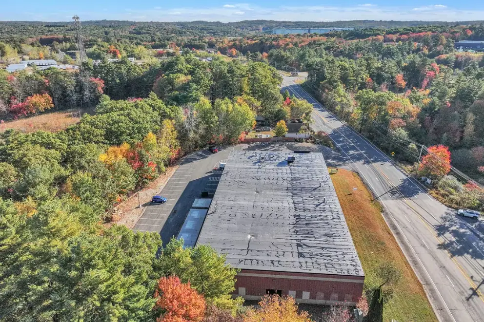 Aerial view over the roof toward the paved rear lot and loading area