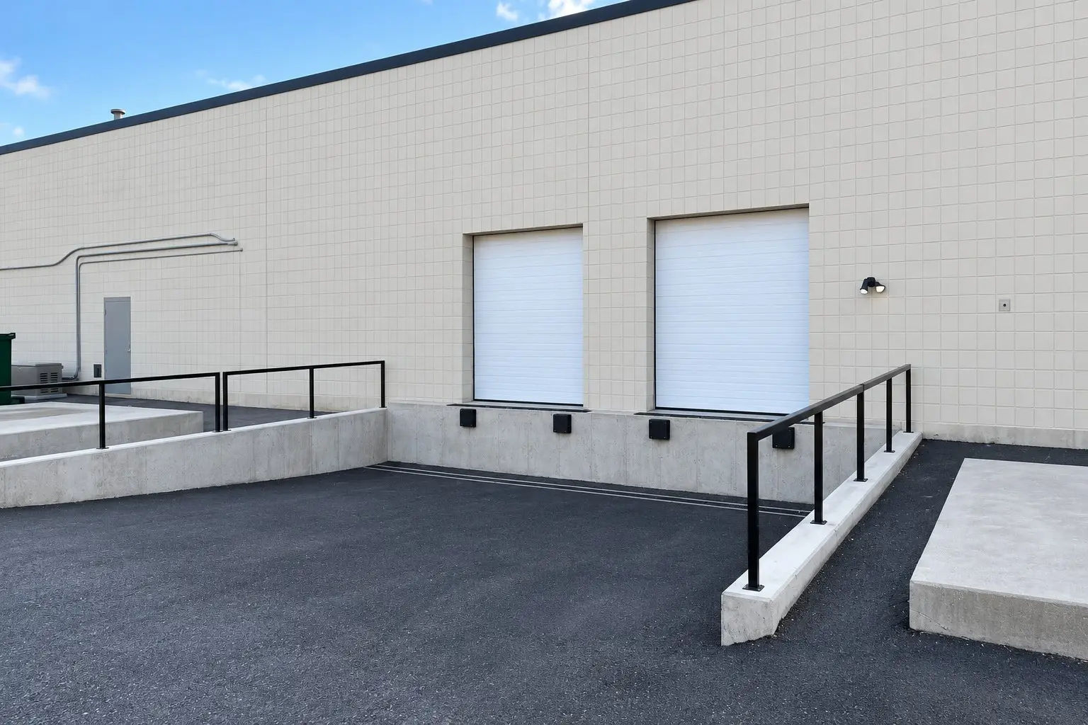 Two dock-high loading doors with a concrete loading platform and railing
